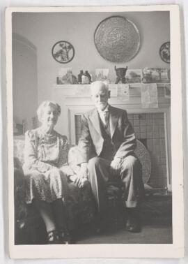 Florence J.M. Dawson and William Bell Dawson, seated by fireplace